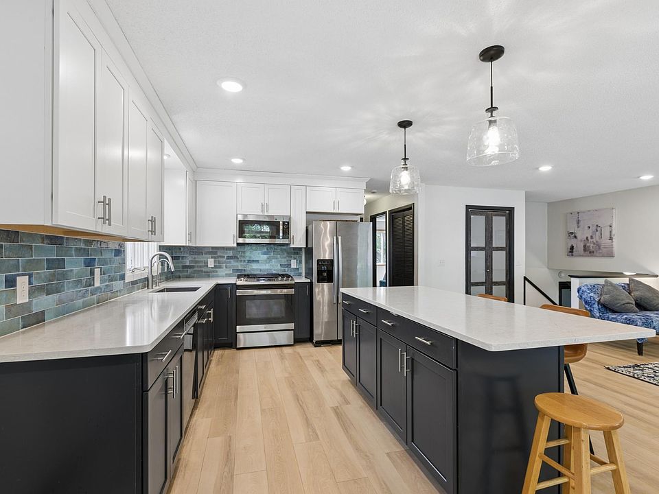 A freshly cleaned kitchen with white counters and light wood floors